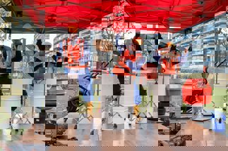 3 bouwvakkers die met drums op olievaten een show weggeven